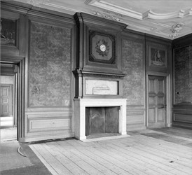 <p>Overzicht van de kamer op een foto uit 1982. Het vermoeden is dat de houten deuromlijstingen, lambrisering en schouwboezem in de tweede helft van de 19e eeuw vernieuwd of passend gemaakt zijn om aan te sluiten bij de hergebruikte interieuronderdelen uit kasteel De Voorst. </p>
